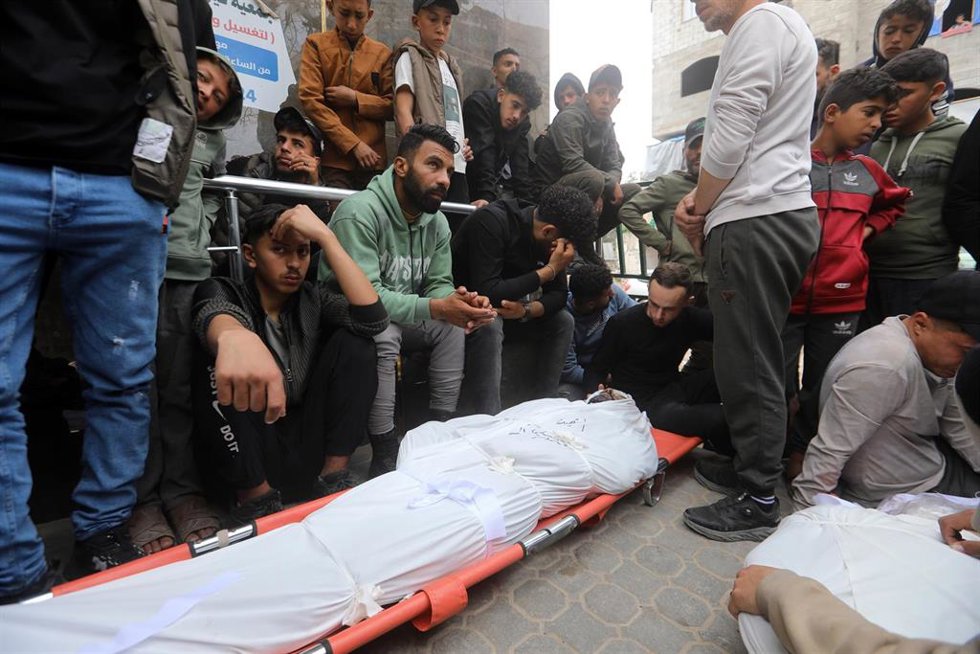 Palestinos junto a varios muertos por un bombardeo del Ejército de Israel contra el campamento de refugiados de Shati, en la Franja de Gaza, a pesar del alto el fuego en vigor desde octubre de 2025