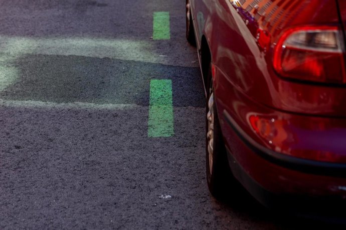 Archivo - Un coche aparcado en una calle con zona verde.