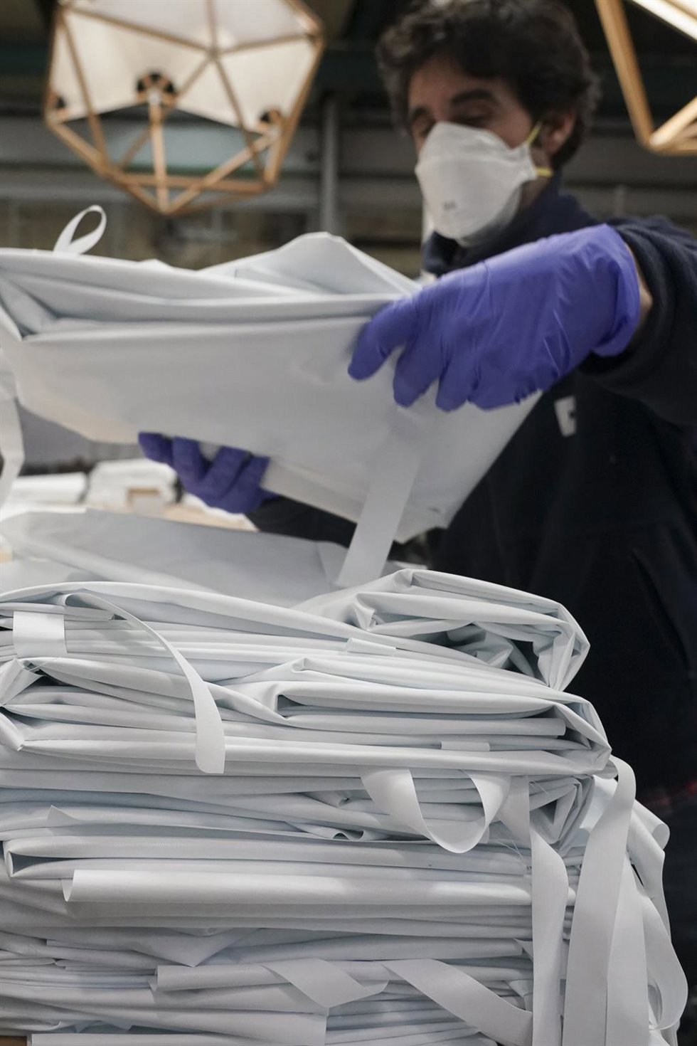 Archivo - Un operario prepara material en una empresa