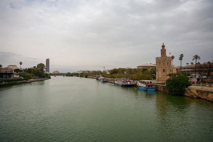 Imagen del río Guadalquivir a su paso por Sevilla con la llegada de una nueva borrasca que trae polvo en suspensión, en foto de archivo.