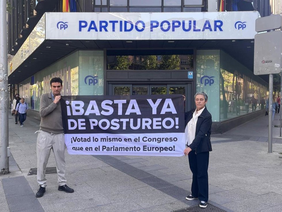 El primer denunciante del caso de la abadía de Montserrat, Miguel Hurtado, y la escritora y periodista Leonor Paqué, junto a la sede del PP.