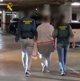 La arrestada, de espaldas, junto a dos agentes de la Guardia Civil.