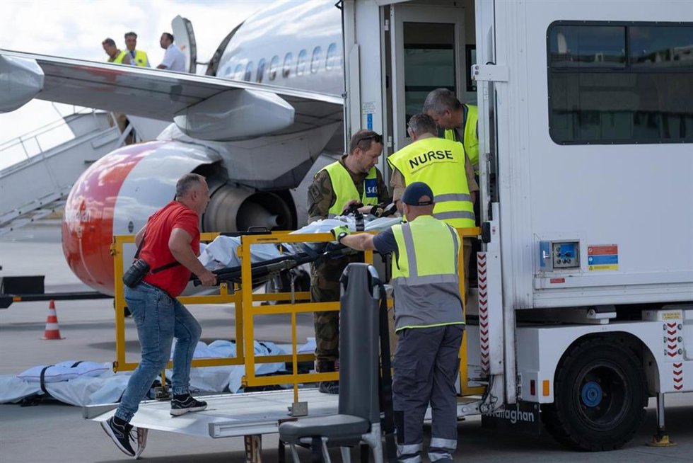 Operarios ayudan a un paciente a entrar en una ambulancia