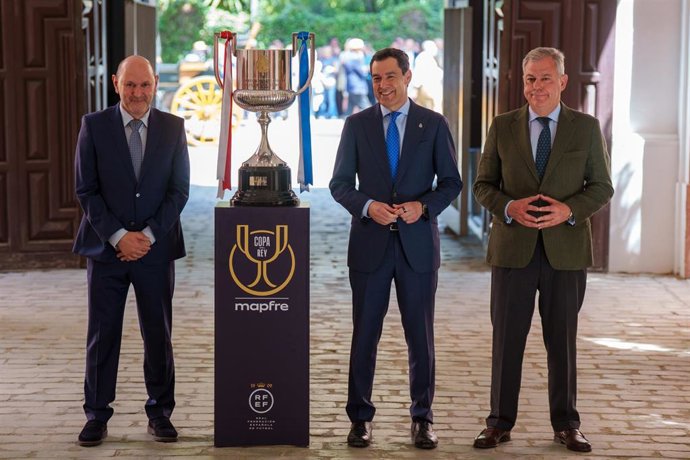 Rafael Louzán, Juanma Moreno y José Luis Sanz, junto al trofeo de la Copa del Rey de fútbol, en San Telmo.