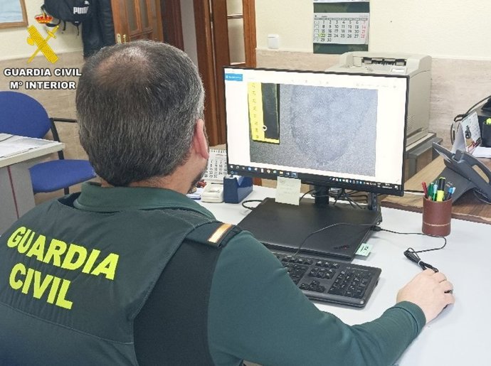 Un agente analiza una huella durante la investigación de los robos en Huércal-Overa (Almería).