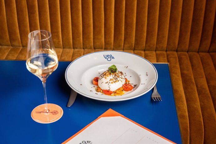 Plato de burrata con tomates cherry y una copa de vino blanco en Casa Vega