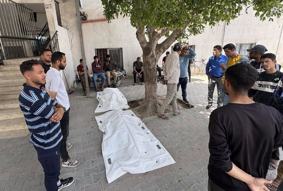 Palestinos junto a los cuerpos de dos muertos en un ataque de Israel contra la Franja de Gaza en abril de 2026, a pesar del alto el fuego en vigor desde octubre de 2025 (archivo)