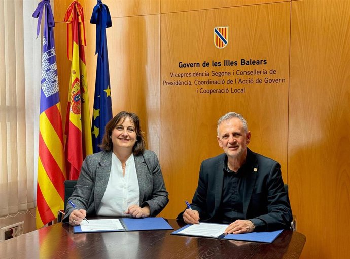 La consellera de Presidencia, Coordinación de la Acción de Gobierno y Cooperación Local, Antònia Maria Estarellas, y el rector de la UIB, Jaume Carot, firman el acuerdo.