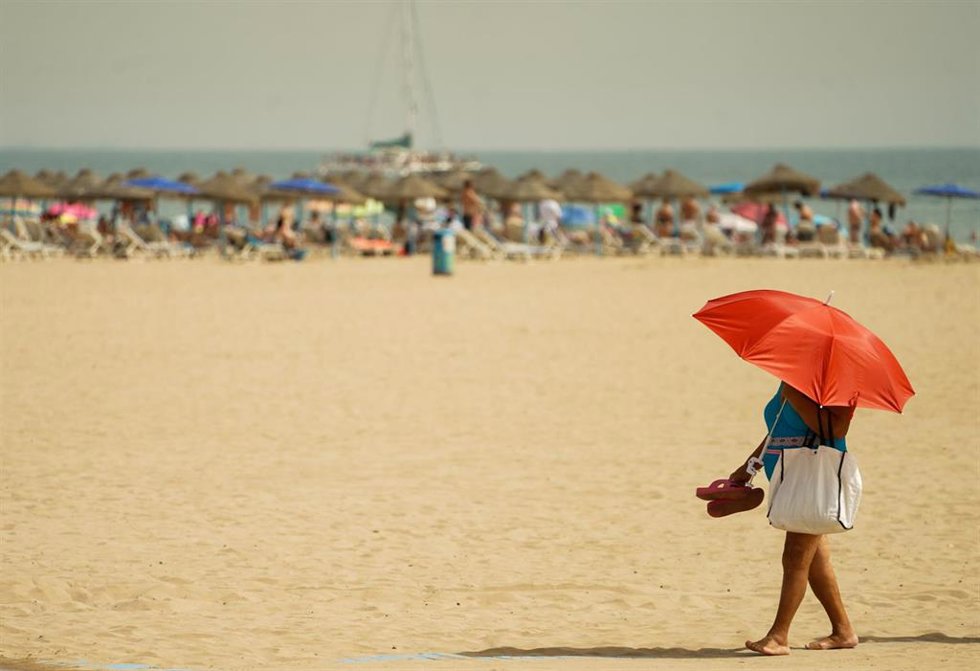 Archivo - Una mujer pasea por la playa de la Malvarrosa. 