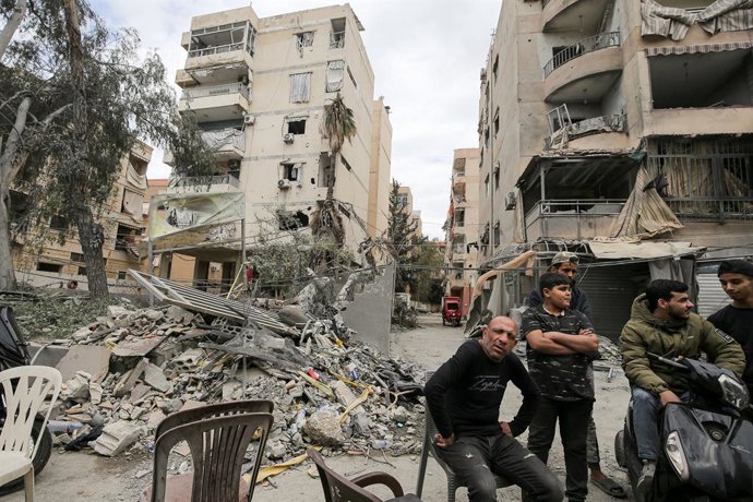 10 de abril de 2026, Beirute, Líbano: Libaneses sentam-se em frente a prédios danificados que foram alvo de ataques aéreos israelenses no bairro de Choueifat, na periferia do subúrbio sul de Beirute, um reduto do Hezbollah, grupo apoiado pelo Irã. O Líban