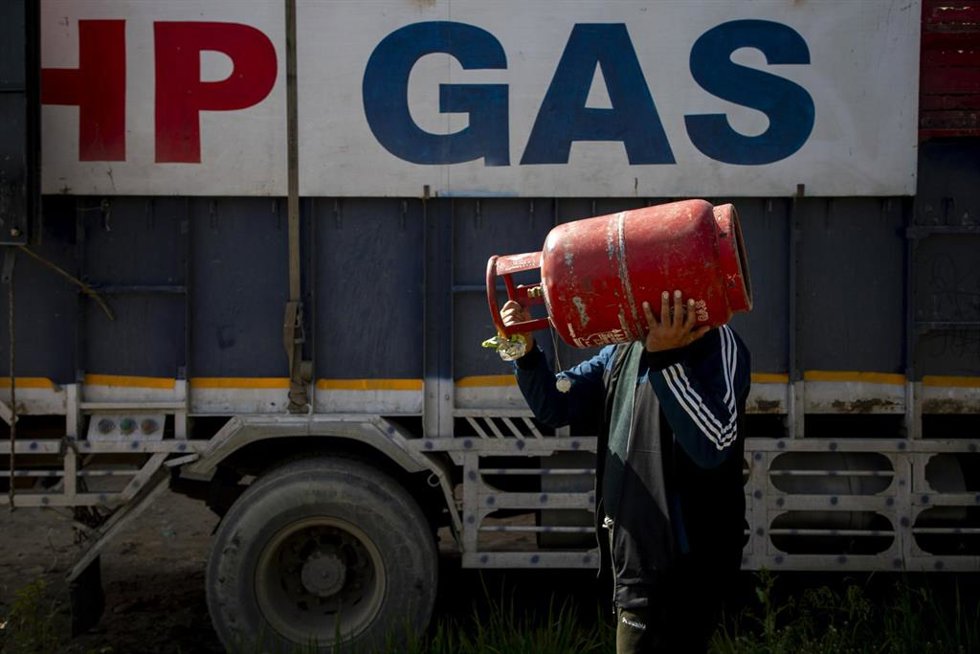 Un hombre carga una bombona de butano en Srinagar (India)