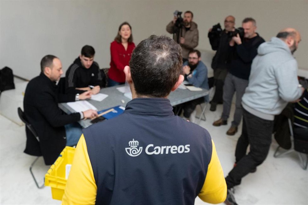 Archivo - Un trabajador de Correos lleva los votos realizados por correo a la mesa electoral.