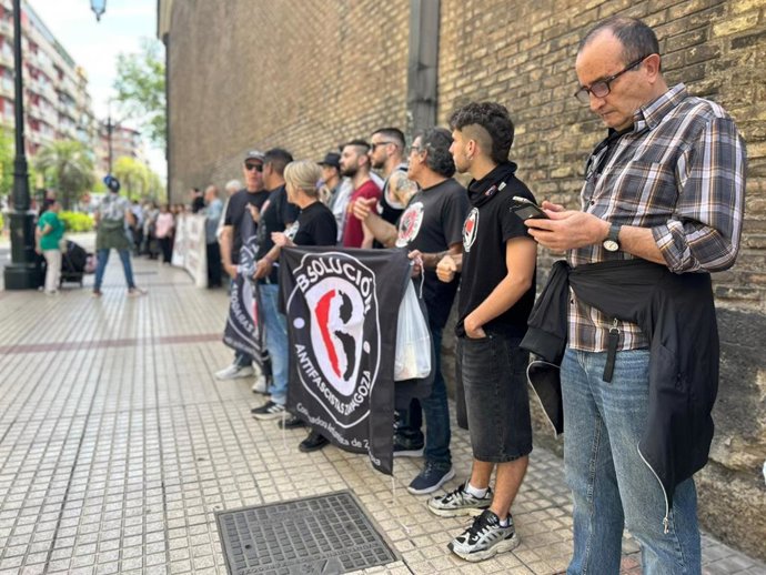 Manifestantes que han participado este sábado en una cadena humana que ha unido la Audiencia Provincial y la sede del PSOE Aragón en Zaragoza para exigir la puesta en libertad de los dos jóvenes que siguen en prisión, condenados por los incidentes de 2019