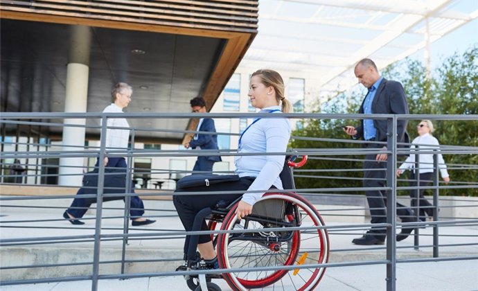 Archivo - Mujer en silla de ruedas por una rampa