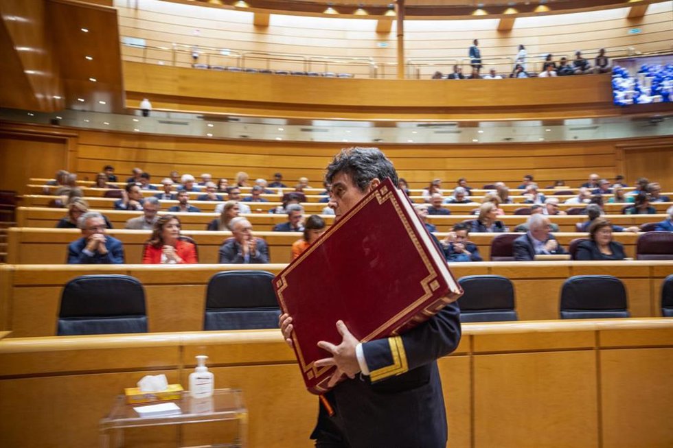 Archivo - Ujier del Senado retira la Constitución española del salón del pleno después del juramento de un nuevo senador. 21/10/2025.