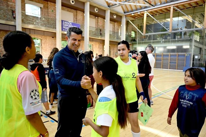 El exfutbolista portugués Luis Figo saluda a varios jóvenes del programa 'Mas Fútbol' de Madrid