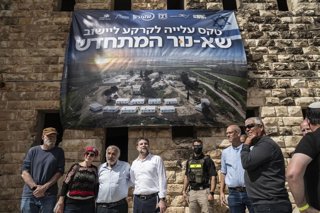 El ministro de Finanzas israelí, el ultraderechista Bezalel Smotrich (en el centro, con camisa blanca) junto a colonos y personal de seguridad al término de una ceremonia de reasentamiento en Sa Nur, al sur de Jenin, en la Cisjordania ocupada por Israel.