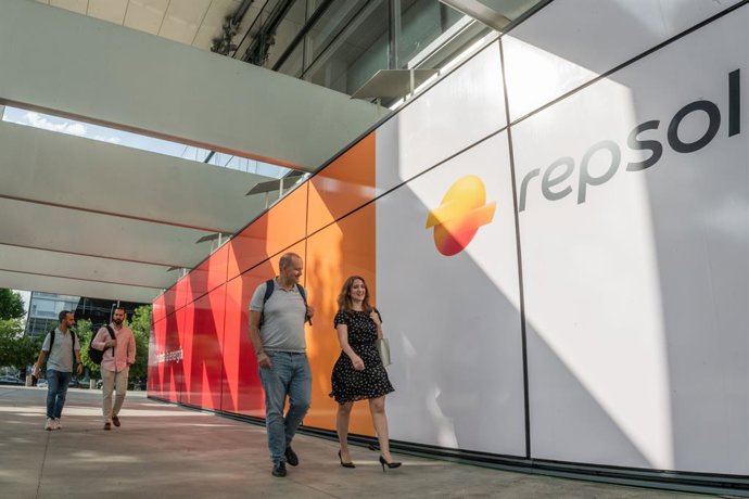 Archivo - Empleados pasando por delante del panel de entrada a Campus con el nuevo logo de Repsol