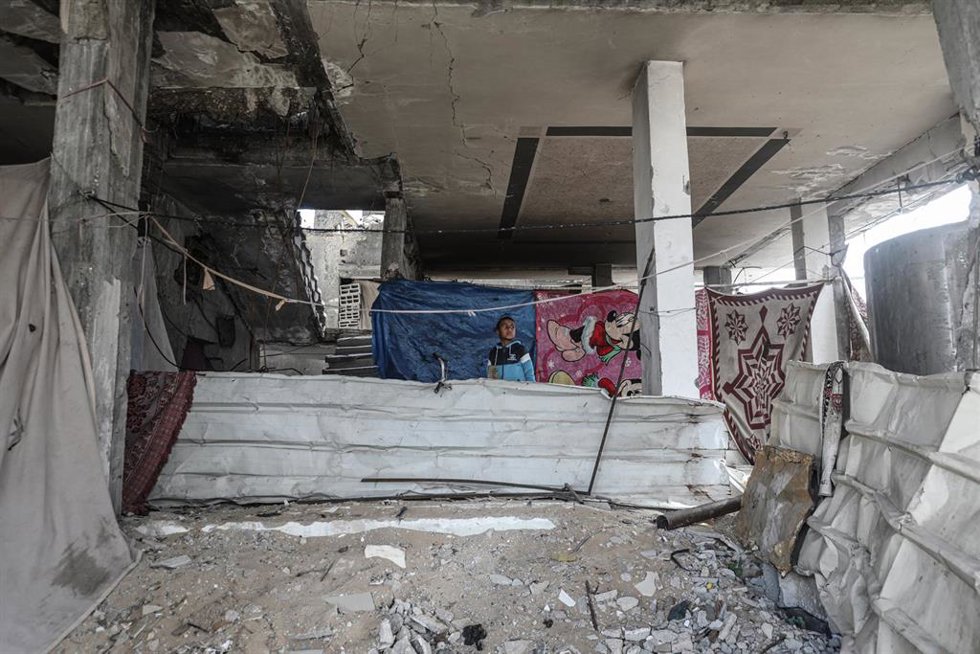 Archivo - Palestinos en un edificio del campamento de refugiados de Al Burej dañado por los ataques del Ejército de Israel contra la Franja de Gaza (archivo)