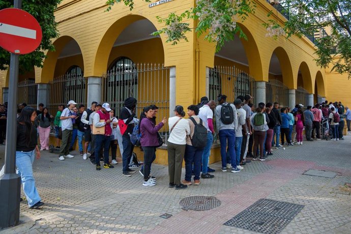 Personas migrantes hacen cola para la tramitación de su regularización administrativa en Sevilla. 