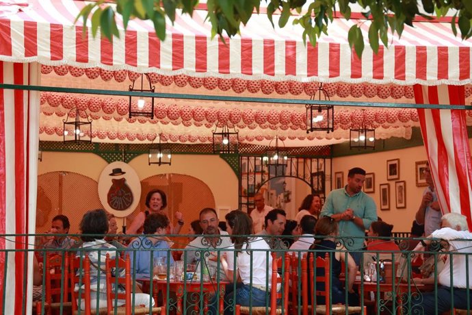 Varias personas en el interior de una caseta en la víspera de la Feria de abril de Sevilla. A 19 de abril de 2026, en Sevilla (Andalucía, España).