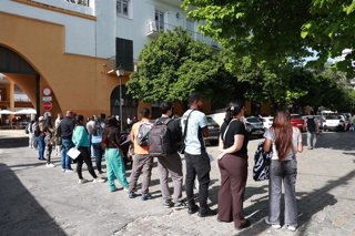 Personas migrantes hacen cola para la tramitación de su regularización administrativa en Sevilla. 