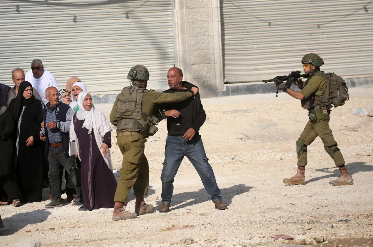 Población palestina desplazada junto a militares israelíes en Cisjordania
