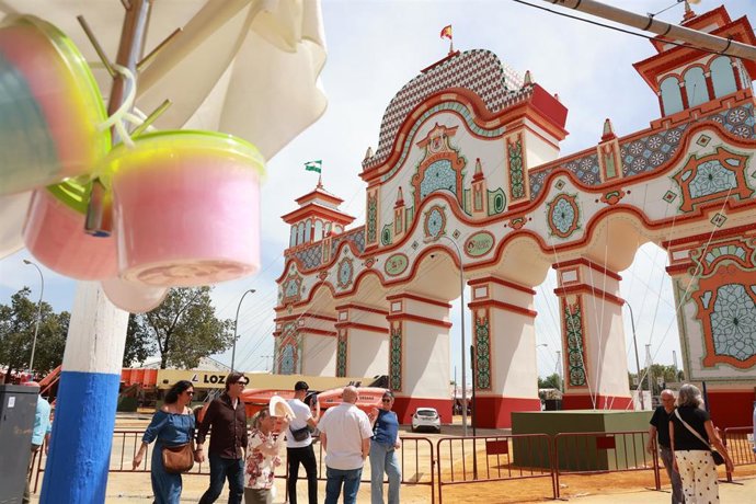 Varias personas pasean por el Real en la víspera de la Feria de abril de Sevilla. 