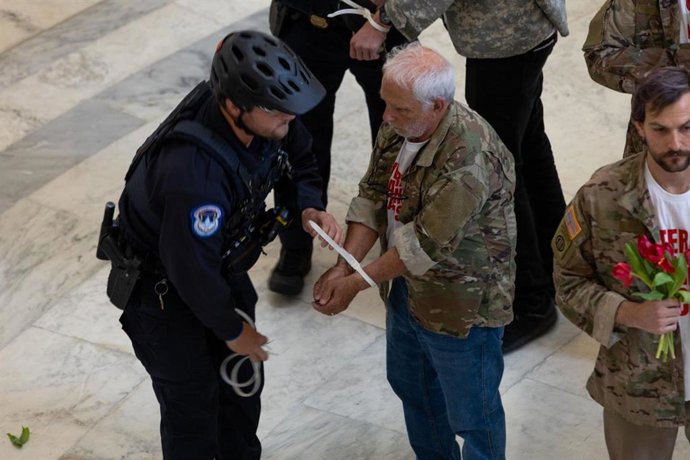 Um policial prende um veterano de guerra americano durante um protesto contra a guerra no Irã, realizado no edifício Cannon da Câmara dos Deputados dos Estados Unidos, em Washington, D.C.
