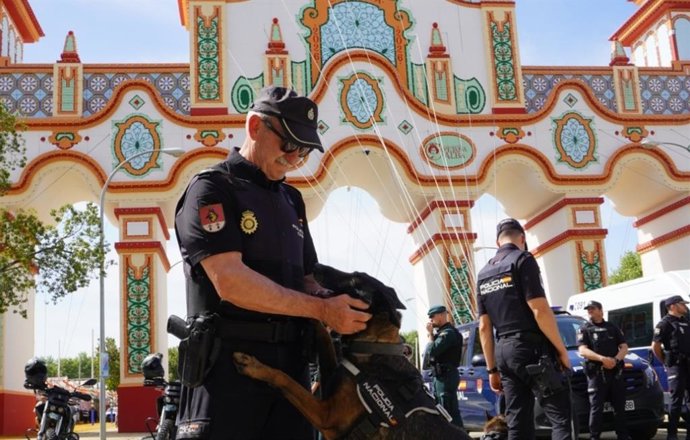 Un agente con un perro adiestrado por la Policía, frente a la portada de la Feria de este año.
