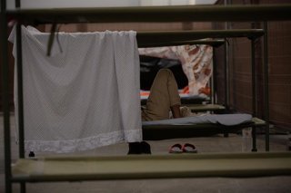 Archivo - Una persona descansa en su cama en el interior de las instalaciones del albergue de Fira Barcelona, habilitado en 2020 por la pandemia del coronavirus para 225 personas sin hogar.