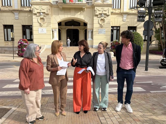 La viceportavoz socialista en el Ayuntamiento de Málaga, Begoña Medina; la concejala Rosa del Mar Rodríguez, y afectados por esperas en la tramitación de ayudas a la dependencia previa a una atención a medios.