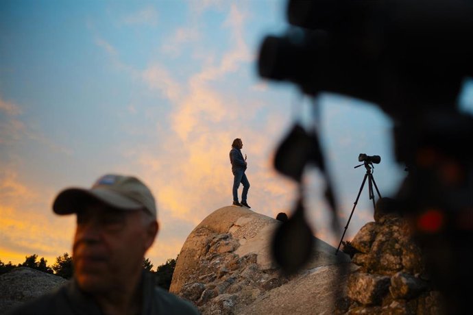 Archivo - Una persona trata de ver un eclipse, en una foto de archivo.