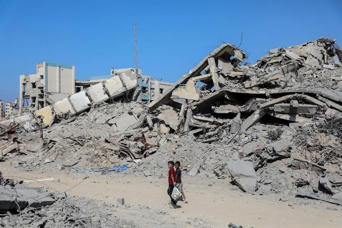 Archivo - Arquivo - GAZA, 20 de outubro de 2025  -- Pessoas são vistas em uma rua com prédios destruídos na cidade de Gaza, em 19 de outubro de 2025. As Forças de Defesa de Israel (IDF) afirmaram em um comunicado no domingo que lançaram uma nova onda de a