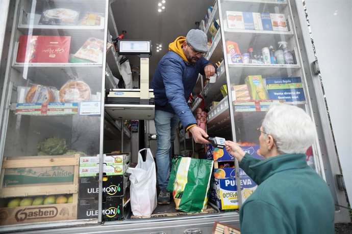 Archivo - Un hombre comprando productos en un comercio ambulante
