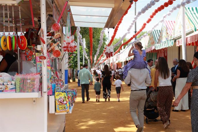Varias personas pasean por el Real de la Feria de Abril.