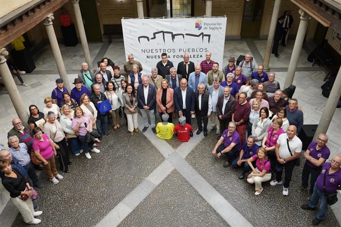 Foto de grupo de la expedición canaria, junto a autoridades y caminantes de Segovia, con la camiseta de la primera caminata (hace 30 Años, roja), y la última (amarilla, 2025).