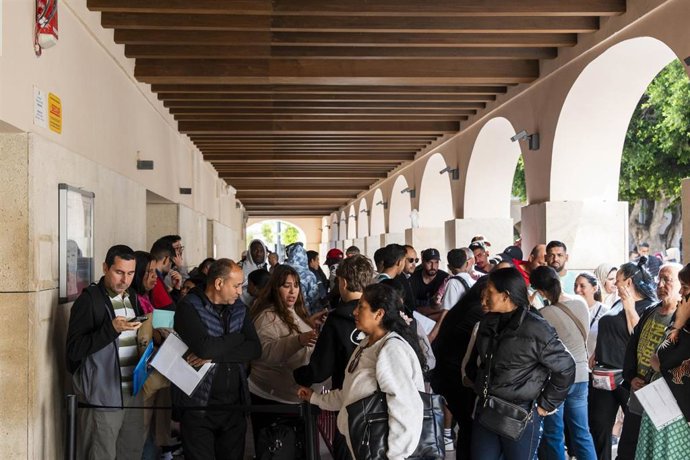 Personas migrantes esperan para tramitar su regularización administrativa en las inmediaciones del Ayuntamiento de Almería.