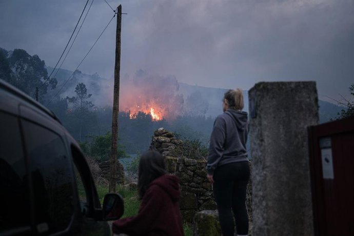 Varias personas observan el incendio forestal en el monte Galleiro, a 6 de abril de 2026, en Ribadetea, Ponteareas, Pontevedra