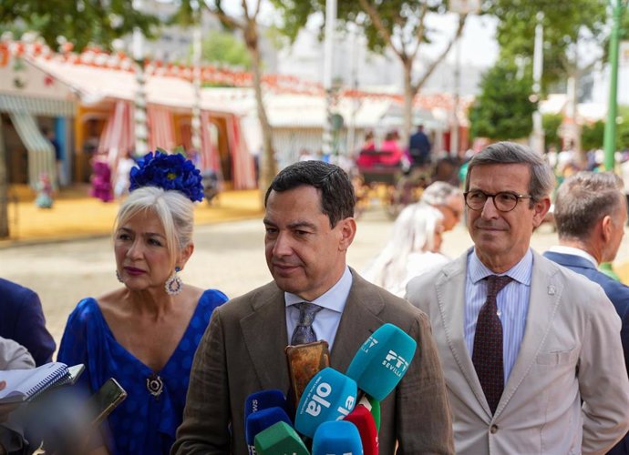 El presidente de la Junta de Andalucía, Juanma Moreno (c), junto a la consejera de Cultura, Patricia del Pozo, y el consejero de Industria,Jorge Paradela (d), atienden a los medios a su llegada a la Feria de Abril. A 22 de abril de 2026, en Sevilla