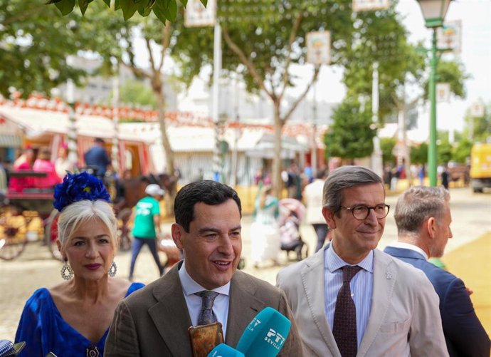 El presidente de la Junta de Andalucía, Juanma Moreno (c), junto a la consejera de Cultura, Patricia del Pozo, y el consejero de Industria, Jorge Paradela (d), atienden a los medios a su llegada a la Feria de Abril. A 22 de abril de 2026, en Sevilla