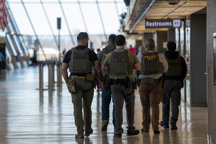 24 de março de 2026, EUA, Dulles: Agentes do Serviço de Imigração e Alfândega (ICE) patrulham o Aeroporto Internacional Washington Dulles, em Dulles. O presidente dos EUA, Donald Trump, ordenou o envio de agentes do ICE para aeroportos em todo o país em m