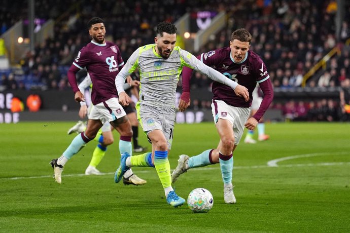 22 April 2026, United Kingdom, Burnley: Manchester City's Rayan Cherki (C) and Burnley's Maxime Esteve battle for the ball during the English Premier League soccer match between Burnley and Manchester City at Turf Moor. Photo: Martin Rickett/PA Wire/dpa