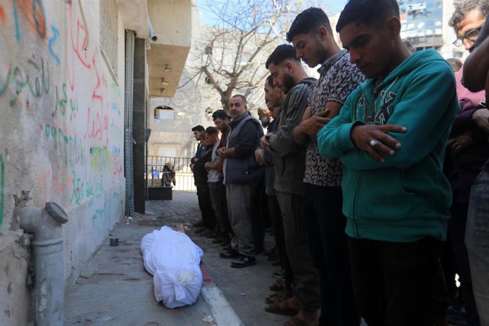 Palestinos rezan junto al cuerpo de una persona muerta en un ataque ejecutado por Israel contra Yabalia, en el norte de la Franja de Gaza, a pesar del alto el fuego en vigor desde octubre de 2025 (archivo)