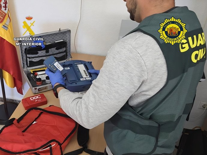 Agente de la Guardia Civil junto con el desfibrilador recuperado