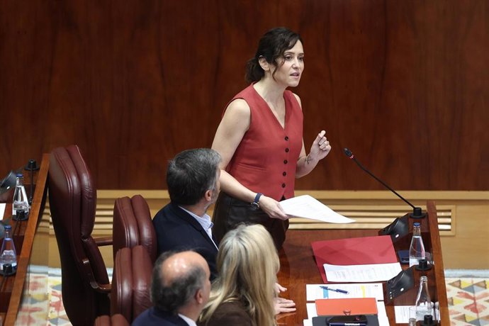 La presidenta de la Comunidad de Madrid, Isabel Díaz Ayuso (d), durante una sesión plenaria en la Asamblea de Madrid