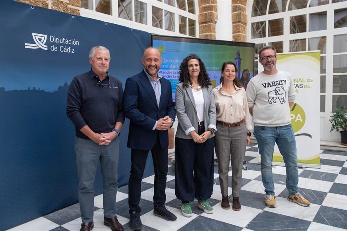 El vicepresidente primero de la Diputación de Cádiz, Juancho Ortiz, y la decana del Colegio Profesional de Periodistas de Andalucía (CPPA), Lorena Mejías, y otros representantes del CPPA, presentando 'La provincia de Cádiz, cuna de la libertad de prensa'.