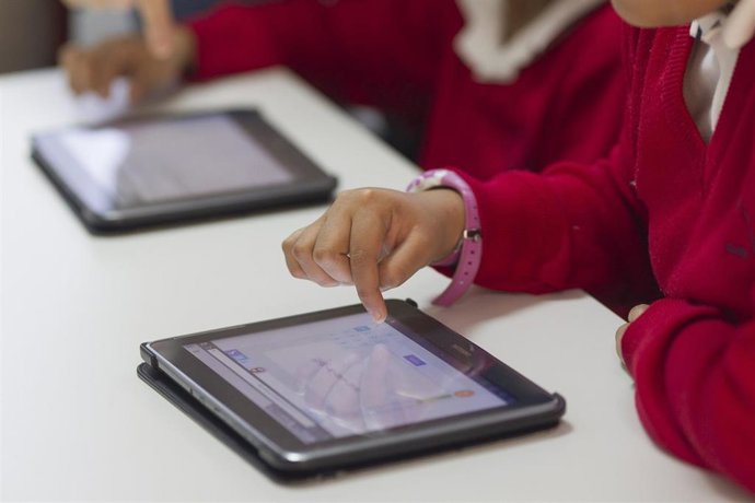 Archivo - Niños utilizando una tablet en el colegio.