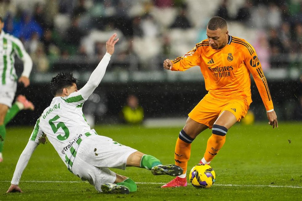 Archivo - Kylian Mbappe intenta sortear a Marc Bartra en el Betis-Real Madrid de LaLiga EA Sports 24-25