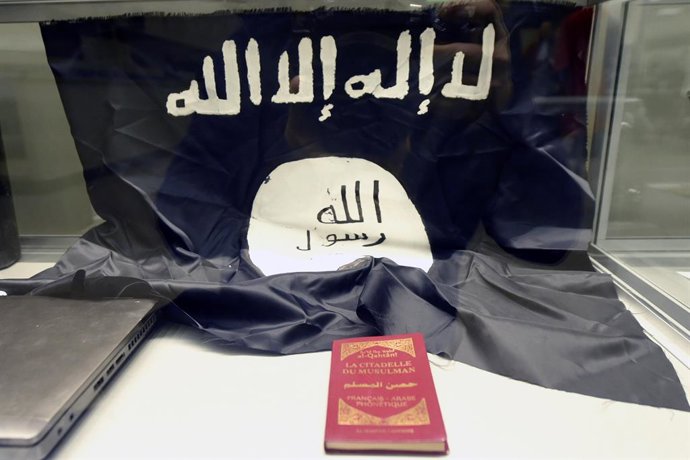Archivo - 06 December 2022, Belgium, Brussels: Peaces of evidence, a book called 'La citadelle du musulman' and an ISIS flag are pictured at Brussels Capital Court before the trial on the March 2016 terrorist attacks. More than six years after the terrori